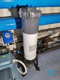 Umkehrosmose:
Die Umkehrosmose oder Reversosmose ist ein physikalisches Verfahren zur Aufkonzentrierung von in Flssigkeiten gelsten Stoffen, bei der mit Druck der natrliche Osmose-Prozess umgekehrt wird.
Sie wird zur Wasseraufbereitung fr Trink- und Prozesswasser, zur Abwasserbehandlung und zum Aufbereiten von Aquarienwasser verwendet. Auch Fruchtsaftkonzentrate werden nach diesem Prinzip hergestellt.
Das Medium, in dem die Konzentration eines bestimmten Stoffes verringert werden soll, ist durch eine halbdurchlssige (semipermeable) Membran von dem Medium getrennt, in dem die Konzentration erhht werden soll. Dieses wird einem Druck ausgesetzt, der hher sein muss als der Druck, der durch das osmotische Verlangen zum Konzentrationsausgleich entsteht. Dadurch knnen die Molekle des Lsungsmittels gegen ihre natrliche osmotische Ausbreitungsrichtung in den Bereich wandern, in dem die gelsten Stoffe bereits geringer konzentriert sind.

Trinkwasser hat einen osmotischen Druck von weniger als 2 bar, der angewendete Druck fr die Umkehrosmose von Trinkwasser betrgt 4 bis 30 bar, je nach verwendeter Membran und Anlagenkonfiguration. Manche anderen Flssigkeiten haben hhere osmotische Drcke, z. B. Meerwasser je nach Salzgehalt etwa 30 bar. Dementsprechend liegen die verwendeten Drcke fr die Meerwasserentsalzung bei 60 bis 80 bar. In einigen extremen Anwendungen, z. B. fr das Aufkonzentrieren von Deponiesickerwasser, werden noch hhere Drcke verwendet.

Die osmotische Membran, die nur die Trgerflssigkeit (Solvent) durchlsst und die gelsten Stoffe (Solute) zurckhlt, muss diesen hohen Drcken standhalten knnen. Wenn der Druckunterschied das osmotische Geflle mehr als ausgleicht, passen die Solventmolekle wie bei einem Filter durch die Membran, whrend die Verunreinigungsmolekle zurckgehalten werden. Im Gegensatz zu einem klassischen Membranfilter verfgen Osmosemembranen nicht ber durchgehende Poren. Vielmehr wandern die Ionen und Molekle durch die Membran hindurch, indem sie durch das Membranmaterial diffundieren. Das Lsungs-Diffusions-Modell beschreibt diesen Vorgang.

Der osmotische Druck steigt mit zunehmendem Konzentrationunterschied. Wird der osmotische Druck gleich dem angelegten Druck, kommt der Prozess zum Stehen. Um dem entgegenzuwirken, wird das Konzentrat stetig abgefhrt. Da das Auskristallisieren (Ausfallen) der Solute (Salz oder Mineralien) in den Membranen verhindert werden muss, ist die Benutzung der Umkehrosmose nur bis zu einer gewissen Maximalkonzentration des Konzentratflusses (reject) sinnvoll. Der Konzentratauslass fliet durch einen Druckregler, und da die Druckerzeugung viel Energie kostet, oft auch durch einen Druckaustauscher, der hilft, mehr Rohflssigkeit zu pumpen.
Meerwasserentsalzung: Beim Betrieb einer Meerwasserentsalzungsanlage zur Trinkwassergewinnung auf Umkehrosmosebasis ist neben der Verwendung von Vorfiltern und/oder Ausflockungsstufen auch der Einsatz verschiedener Chemikalien unerlsslich. Zum einen kann der pH-Wert durch Zugabe von Suren erniedrigt werden, eine andere Methode, das Auskristallisieren von Salzen zu verhindern, ist die Zugabe von Antibelagmitteln (engl. Antiscaling). Bei diesen Substanzen handelt es sich um polymere Verbindungen auf Phosphat- oder Maleinsurebasis, welche die sich bildenden Kristallite umschlieen und so verhindern, dass kristalline Ausfllungen auf der Membran entstehen knnen.

Gerade Anlagen, die das aufzubereitende Wasser direkt aus dem Meer beziehen (Open Intake), mssen mittels Bioziden (meist auf Brombasis) diskontinuierlich von sich bildenden Biofilmen befreit werden. Leider wird in vielen sdlichen Lndern auch gerne Chlor zur Desinfektion vor Membrananlagen eingesetzt, das aufgrund der Chlorempfindlichkeit der Membranen dann wieder aufwendig entfernt werden muss.

Dennoch muss die Membran in regelmigen Abstnden gereinigt werden, um einen konstanten Durchsatz an trinkfertigem Wasser zu gewhrleisten.

Das direkt aus dem Umkehrosmoseprozess stammende Wasser ist sehr ionenarm, sodass seine direkte Verwendung als Trinkwasser umstritten ist. Vor Einspeisung in das Trinkwassersystem werden deshalb aus geschmacklichen und gesundheitlichen Grnden wieder Salze zugefgt. Die Zumischung von Salzen wird in der Trinkwasseraufbereitung ber ultrafiltriertes Rohwasser durchgefhrt. Dadurch wird gewhrleistet, dass nur bakteriell unbedenkliches Rohwasser in das ffentliche Trinkwassernetz gelangt. Das Permeat wird meist durch Marmorfilter erreicht, wobei das Kalk-Kohlensure-Gleichgewicht wieder eingestellt wird.
Aquarientechnik: In der Aquarientechnik ist die Umkehrosmose eine Methode zur Gewinnung von gereinigtem, Ionen-freiem Wasser.

In Umkehrosmoseanlagen fr Aquarien sind der Membran in der Regel ein Feinfilter und ein Aktivkohlefilter vorgeschaltet, um die Membran vor mechanischer Verschmutzung und vor im Trinkwasser ggf. vorhandenem Chlor zu schtzen. Die Anlage bentigt Splwasser, um die sich auf der Eingangsseite ansammelnden Ionen aus dem System zu entfernen. Die meisten Anlagen verbrauchen die drei- bis vierfache Menge des erzeugten gereinigten Wassers als Splwasser.

Der Vorteil der Umkehrosmose gegenber dem zur Wasserenthrtung ebenfalls einsetzbaren Ionenaustauscher auf Kunstharzbasis (bekannt auch als Filterpatronen zur Trinkwasseraufbereitung) liegt darin, dass die Ionen nur entfernt und nicht durch andere ersetzt werden. Ionenaustauscher ersetzen die Calciumionen des harten Wassers durch Natriumionen, die besonders bei hoher Ausgangshrte eine hohe Konzentration erreichen. Ionenaustauscher mssen zudem entweder regelmig ersetzt (Kaffeefilter) oder mit Kochsalzlsung regeneriert (z. B. in der Geschirrsplmaschine) werden.

Wenn fr ein Aquarium Umkehrosmose-Wasser verwendet werden soll, muss entweder ein Teil Leitungswasser beigemischt werden, oder es mssen danach gezielt Aufhrtesalze zugesetzt werden, damit das Wasser die fr Tiere und Pflanzen erforderlichen Mineralstoffe enthlt. Ausnahme sind extreme Weichwasserfische und Schwarzwasseraquarien. Zudem besteht wegen der fehlenden Pufferwirkung die Gefahr, dass der pH-Wert des Wassers in den sauren Bereich umschlgt.

Im Aquaristenjargon sind die Krzel UO (z. B. UO-Wasser) und UOA (= Umkehrosmoseanlage) gebruchlich.
Medizintechnik: Die Umkehrosmose wird als Vorstufe zur Herstellung von Reinstwasser fr die Medizintechnik verwendet. Der Einsatz von Reinstwasser ist zum Beispiel in der Dialyse fr das Dialysegert notwendig. Reinstwasser enthlt im Gegensatz zu herkmmlichem Wasser (dieses enthlt z. B. Mineralstoffe wie Magnesium) so gut wie keine Fremdstoffe. Wasser, welches durch Injektion in den Krper gelangt, oder mit spter in den Krper zurckzufhrenden Krperflssigkeiten oder Blut in Kontakt kommt, muss den Spezifkationen von Wasser fr Injektionszwecke entsprechen.
Weinbereitung: In der Weinbereitung wird die Umkehrosmose eingesetzt, um gutes Traubenmaterial zu einem sehr dichten Most zu verarbeiten. Der Most erfhrt eine Aufkonzentration aller Inhaltsstoffe, dementsprechend ist es nicht mglich, aus sauren Trauben einen Spitzenwein zu gewinnen. Viele Spitzenweine durchlaufen einen solchen Veredlungsgang (v. a. kalifornische Erzeugnisse, aber auch franzsische, sterreichische, italienische). In Deutschland ist dieses Verfahren nur bei Weiweinen zugelassen.
Quelle: www.wikipedia.org