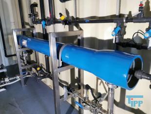 Umkehrosmose:
Die Umkehrosmose oder Reversosmose ist ein physikalisches Verfahren zur Aufkonzentrierung von in Flssigkeiten gelsten Stoffen, bei der mit Druck der natrliche Osmose-Prozess umgekehrt wird.
Sie wird zur Wasseraufbereitung fr Trink- und Prozesswasser, zur Abwasserbehandlung und zum Aufbereiten von Aquarienwasser verwendet. Auch Fruchtsaftkonzentrate werden nach diesem Prinzip hergestellt.
Das Medium, in dem die Konzentration eines bestimmten Stoffes verringert werden soll, ist durch eine halbdurchlssige (semipermeable) Membran von dem Medium getrennt, in dem die Konzentration erhht werden soll. Dieses wird einem Druck ausgesetzt, der hher sein muss als der Druck, der durch das osmotische Verlangen zum Konzentrationsausgleich entsteht. Dadurch knnen die Molekle des Lsungsmittels gegen ihre natrliche osmotische Ausbreitungsrichtung in den Bereich wandern, in dem die gelsten Stoffe bereits geringer konzentriert sind.

Trinkwasser hat einen osmotischen Druck von weniger als 2 bar, der angewendete Druck fr die Umkehrosmose von Trinkwasser betrgt 4 bis 30 bar, je nach verwendeter Membran und Anlagenkonfiguration. Manche anderen Flssigkeiten haben hhere osmotische Drcke, z. B. Meerwasser je nach Salzgehalt etwa 30 bar. Dementsprechend liegen die verwendeten Drcke fr die Meerwasserentsalzung bei 60 bis 80 bar. In einigen extremen Anwendungen, z. B. fr das Aufkonzentrieren von Deponiesickerwasser, werden noch hhere Drcke verwendet.

Die osmotische Membran, die nur die Trgerflssigkeit (Solvent) durchlsst und die gelsten Stoffe (Solute) zurckhlt, muss diesen hohen Drcken standhalten knnen. Wenn der Druckunterschied das osmotische Geflle mehr als ausgleicht, passen die Solventmolekle wie bei einem Filter durch die Membran, whrend die Verunreinigungsmolekle zurckgehalten werden. Im Gegensatz zu einem klassischen Membranfilter verfgen Osmosemembranen nicht ber durchgehende Poren. Vielmehr wandern die Ionen und Molekle durch die Membran hindurch, indem sie durch das Membranmaterial diffundieren. Das Lsungs-Diffusions-Modell beschreibt diesen Vorgang.

Der osmotische Druck steigt mit zunehmendem Konzentrationunterschied. Wird der osmotische Druck gleich dem angelegten Druck, kommt der Prozess zum Stehen. Um dem entgegenzuwirken, wird das Konzentrat stetig abgefhrt. Da das Auskristallisieren (Ausfallen) der Solute (Salz oder Mineralien) in den Membranen verhindert werden muss, ist die Benutzung der Umkehrosmose nur bis zu einer gewissen Maximalkonzentration des Konzentratflusses (reject) sinnvoll. Der Konzentratauslass fliet durch einen Druckregler, und da die Druckerzeugung viel Energie kostet, oft auch durch einen Druckaustauscher, der hilft, mehr Rohflssigkeit zu pumpen.
Meerwasserentsalzung: Beim Betrieb einer Meerwasserentsalzungsanlage zur Trinkwassergewinnung auf Umkehrosmosebasis ist neben der Verwendung von Vorfiltern und/oder Ausflockungsstufen auch der Einsatz verschiedener Chemikalien unerlsslich. Zum einen kann der pH-Wert durch Zugabe von Suren erniedrigt werden, eine andere Methode, das Auskristallisieren von Salzen zu verhindern, ist die Zugabe von Antibelagmitteln (engl. Antiscaling). Bei diesen Substanzen handelt es sich um polymere Verbindungen auf Phosphat- oder Maleinsurebasis, welche die sich bildenden Kristallite umschlieen und so verhindern, dass kristalline Ausfllungen auf der Membran entstehen knnen.

Gerade Anlagen, die das aufzubereitende Wasser direkt aus dem Meer beziehen (Open Intake), mssen mittels Bioziden (meist auf Brombasis) diskontinuierlich von sich bildenden Biofilmen befreit werden. Leider wird in vielen sdlichen Lndern auch gerne Chlor zur Desinfektion vor Membrananlagen eingesetzt, das aufgrund der Chlorempfindlichkeit der Membranen dann wieder aufwendig entfernt werden muss.

Dennoch muss die Membran in regelmigen Abstnden gereinigt werden, um einen konstanten Durchsatz an trinkfertigem Wasser zu gewhrleisten.

Das direkt aus dem Umkehrosmoseprozess stammende Wasser ist sehr ionenarm, sodass seine direkte Verwendung als Trinkwasser umstritten ist. Vor Einspeisung in das Trinkwassersystem werden deshalb aus geschmacklichen und gesundheitlichen Grnden wieder Salze zugefgt. Die Zumischung von Salzen wird in der Trinkwasseraufbereitung ber ultrafiltriertes Rohwasser durchgefhrt. Dadurch wird gewhrleistet, dass nur bakteriell unbedenkliches Rohwasser in das ffentliche Trinkwassernetz gelangt. Das Permeat wird meist durch Marmorfilter erreicht, wobei das Kalk-Kohlensure-Gleichgewicht wieder eingestellt wird.
Aquarientechnik: In der Aquarientechnik ist die Umkehrosmose eine Methode zur Gewinnung von gereinigtem, Ionen-freiem Wasser.

In Umkehrosmoseanlagen fr Aquarien sind der Membran in der Regel ein Feinfilter und ein Aktivkohlefilter vorgeschaltet, um die Membran vor mechanischer Verschmutzung und vor im Trinkwasser ggf. vorhandenem Chlor zu schtzen. Die Anlage bentigt Splwasser, um die sich auf der Eingangsseite ansammelnden Ionen aus dem System zu entfernen. Die meisten Anlagen verbrauchen die drei- bis vierfache Menge des erzeugten gereinigten Wassers als Splwasser.

Der Vorteil der Umkehrosmose gegenber dem zur Wasserenthrtung ebenfalls einsetzbaren Ionenaustauscher auf Kunstharzbasis (bekannt auch als Filterpatronen zur Trinkwasseraufbereitung) liegt darin, dass die Ionen nur entfernt und nicht durch andere ersetzt werden. Ionenaustauscher ersetzen die Calciumionen des harten Wassers durch Natriumionen, die besonders bei hoher Ausgangshrte eine hohe Konzentration erreichen. Ionenaustauscher mssen zudem entweder regelmig ersetzt (Kaffeefilter) oder mit Kochsalzlsung regeneriert (z. B. in der Geschirrsplmaschine) werden.

Wenn fr ein Aquarium Umkehrosmose-Wasser verwendet werden soll, muss entweder ein Teil Leitungswasser beigemischt werden, oder es mssen danach gezielt Aufhrtesalze zugesetzt werden, damit das Wasser die fr Tiere und Pflanzen erforderlichen Mineralstoffe enthlt. Ausnahme sind extreme Weichwasserfische und Schwarzwasseraquarien. Zudem besteht wegen der fehlenden Pufferwirkung die Gefahr, dass der pH-Wert des Wassers in den sauren Bereich umschlgt.

Im Aquaristenjargon sind die Krzel UO (z. B. UO-Wasser) und UOA (= Umkehrosmoseanlage) gebruchlich.
Medizintechnik: Die Umkehrosmose wird als Vorstufe zur Herstellung von Reinstwasser fr die Medizintechnik verwendet. Der Einsatz von Reinstwasser ist zum Beispiel in der Dialyse fr das Dialysegert notwendig. Reinstwasser enthlt im Gegensatz zu herkmmlichem Wasser (dieses enthlt z. B. Mineralstoffe wie Magnesium) so gut wie keine Fremdstoffe. Wasser, welches durch Injektion in den Krper gelangt, oder mit spter in den Krper zurckzufhrenden Krperflssigkeiten oder Blut in Kontakt kommt, muss den Spezifkationen von Wasser fr Injektionszwecke entsprechen.
Weinbereitung: In der Weinbereitung wird die Umkehrosmose eingesetzt, um gutes Traubenmaterial zu einem sehr dichten Most zu verarbeiten. Der Most erfhrt eine Aufkonzentration aller Inhaltsstoffe, dementsprechend ist es nicht mglich, aus sauren Trauben einen Spitzenwein zu gewinnen. Viele Spitzenweine durchlaufen einen solchen Veredlungsgang (v. a. kalifornische Erzeugnisse, aber auch franzsische, sterreichische, italienische). In Deutschland ist dieses Verfahren nur bei Weiweinen zugelassen.
Quelle: www.wikipedia.org