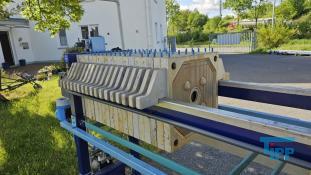 Filterpresse:
Eine Filterpresse setzt sich aus mehreren aneinander gereihten Elementen, den Filterplatten zusammen. Um diese Platten ist eine Membran gespannt, die nur Flssigkeiten durchlsst. Die Filterplatten werden unter hohem Druck zusammengepresst (bis 600 bar), whrend zwischen den Filterplatten von innen nach auen Schlamm mit 10-20 bar gepresst wird. Der Schlamm verdichtet sich immer mehr whrend das Wasser aus der Presse raus luft. Ab einer bestimmten Dichte muss der zum Filterkuchen verdichtete Schlamm entfernt werden, dazu wird der Druck langsam abgelassen und die Filterpresse geffnet. Wichtiges Anwendungsgebiet der Filterpresse ist die Abwasseraufbereitung.

Haupteinsatzgebiet der Filterpressen oder auch Kammerfilterpressen ist die Entwsserung von Klrschlmmen. Die der Presse entnommenen Filterkuchen werden wegen der meist vorliegenden Schadstoffbelastung auf Deponien oder in Mllverbrennungsanlagen entsorgt. Sie sind nur in Ausnahmefllen fr die Ausbringung als Dnger auf landwirtschaftlich genutzten Flchen geeignet.
Kammerfilterpresse:
Aus mehreren Kammern bestehende Filterpresse.
Membran:
Natrliche oder knstlich hergestellte flchige Gebilde, die fluide Phasen oder auch zwei Volumina einer Phase mit unterschiedlicher Zusammensetzung voneinander zu trennen imstande sind und deren Fhigkeit darin besteht, den Stoffaustausch zwischen ihnen zu ermglichen, werden als Membranen (lat. Membrana=Hutchen) bezeichnet. Man unterscheidet in Anhngigkeit von der Trenngrenze zwischen Mikrofiltration, Ultrafiltration, Nanofiltration und Umkehrosmose.
Membrankonfiguration, Membranfilter:
Membranen werden in flacher oder rohrartiger Form hergestellt. Rohrfrmige Membranen bis zu einem Innendurchmesser von 1 mm werden als Hohlfasermodul oder auch als Kapillarmodul bezeichnet. Bei greren Durchmessern spricht man von Rohrmodulen. Bei den flachartigen Membranen unterscheidet man zwischen Wickel- und Plattenmodulen. Plattenmodule sind aufgrund des offenen Kanals weniger anfllig gegenber Fouling als Wickelmodule. Wickelmodule ermglichen jedoch eine hhere Packungsdichte.
Quelle: www.wasser-wissen.de